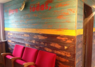 Bunte Holzbretter Wand und rote Sessel