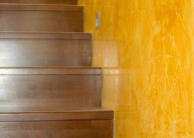 Stucco Lustro orange Wand und braune Holztreppe
